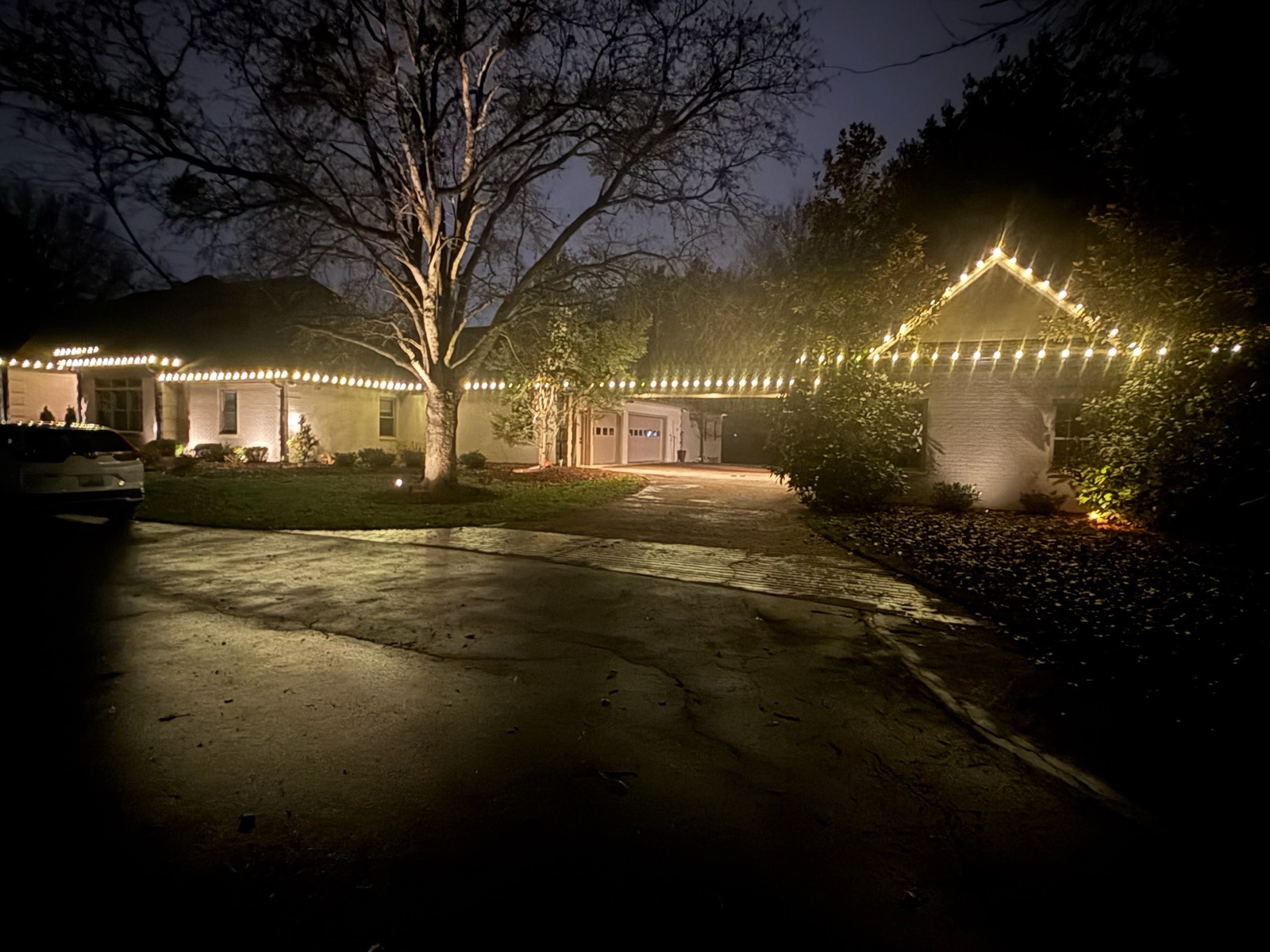 Home at dusk with warm white holiday lighting glowing along the roofline, Bowling Green KY